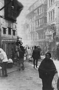 people walk through streets while smoke is in the air