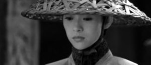 a woman in a straw hat looks down