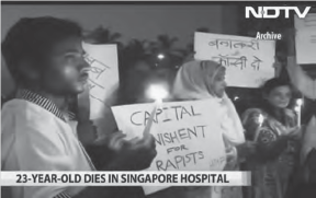 Screenshot showing people holding candles and holding paper with slogans