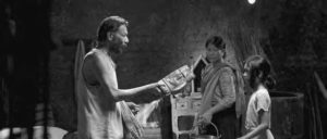 a man speaks to two young women