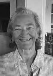 Head to shoulder photograph of Judith S. Ames as an elderly woman. She smiles radiantly and is wearing a striped top. 