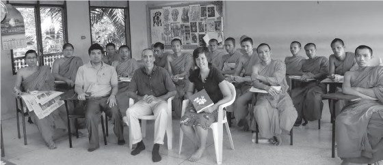 photo of a group of people sitting in desks. many are wearing monk robes
