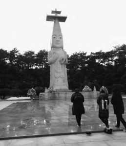 photo of a temple statue and a few onlookers