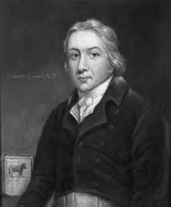 painted portrait of a man. there is a book with a picture of a cow on it in the background