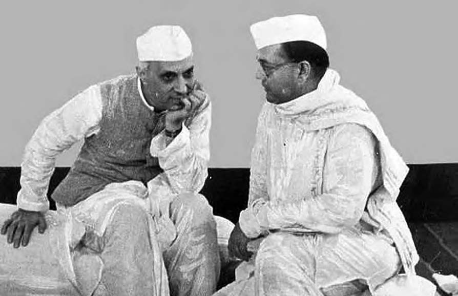 two men speak closely with each other