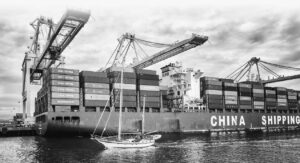 a container ship with containers stacked high with machine cranes on the ship