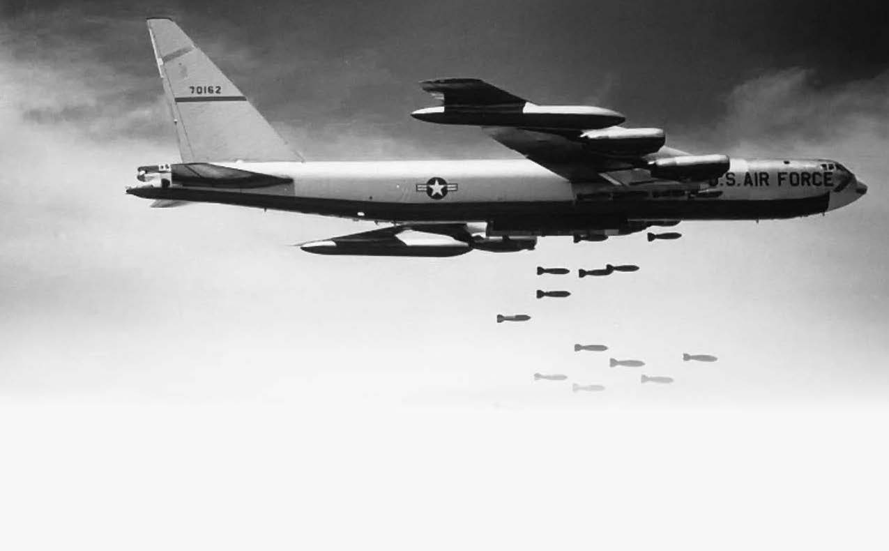 black and white photo of a plan dropping bombs