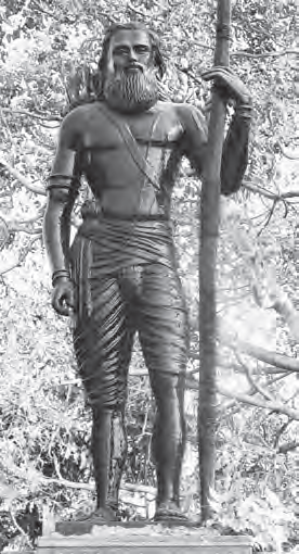 statue of a man holding a large stick