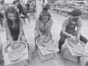 photo of several people making pottery