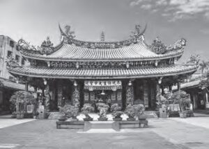 photo of an elaborate gate with bonsai in front of it