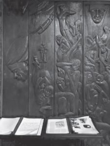photo of a guest book and a carved relief of people suffering