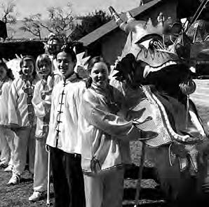 several people in matching uniforms stand with a dragon head