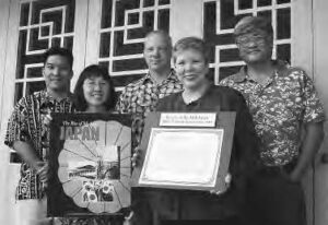 a group poses for a photo with the book cover