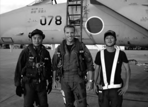 Image of three people standing front of a airplane
