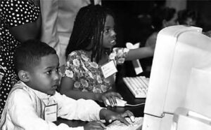 photo of two young children on the computer