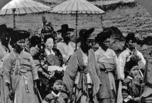 photo of many people in robes walking among a painted woman