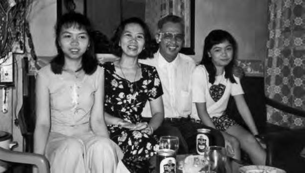 a family of a mother, father, and two daughters pose for a photo