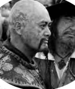 A man standing in crowed with a Western man looking at him on his side